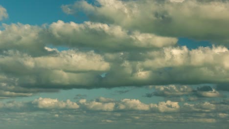 large layers and layers of white clouds moving across the frame in a blue sky