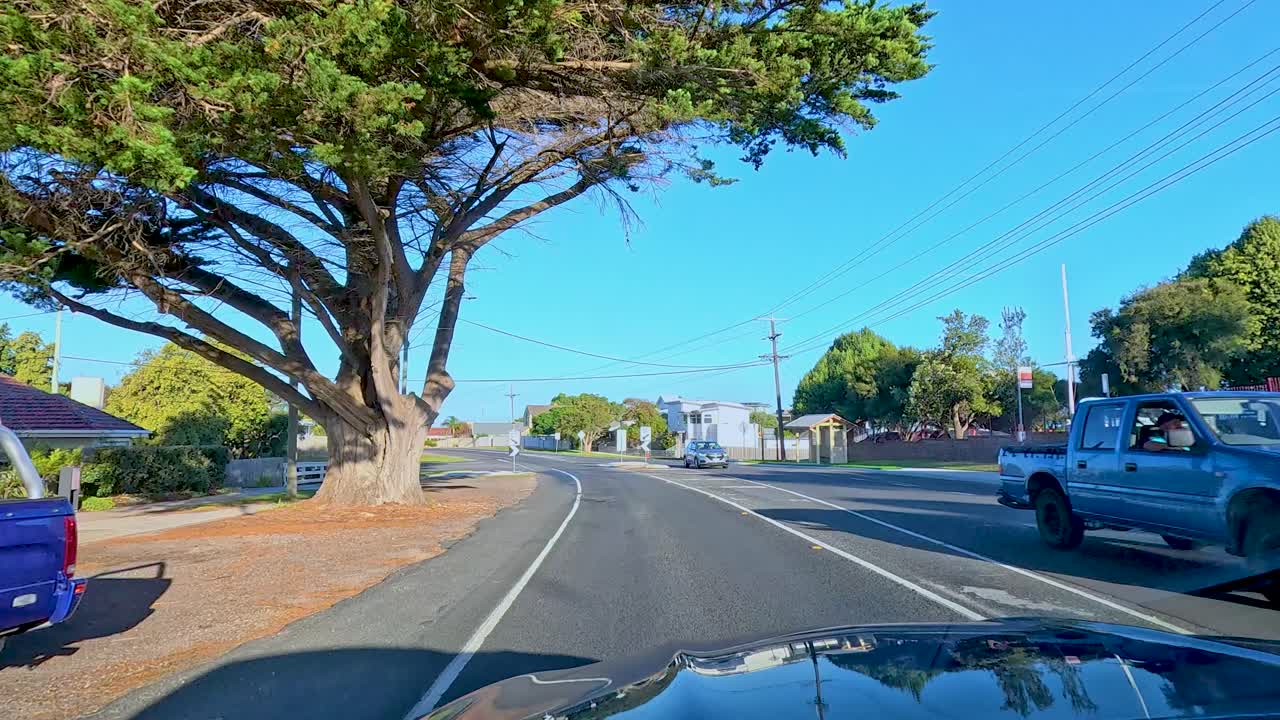 A car journey along a sunlit road in Bellarine, Victoria, showcasing vibrant landscapes and clear skies