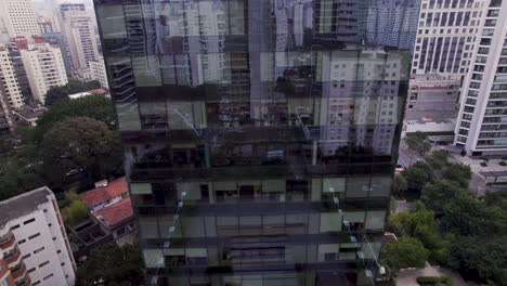 El-Dron-Sube-Frente-A-Una-Torre-Comercial-Reflejada-Mientras-El-Paisaje-De-Los-Edificios-De-São-Paulo-Se-Revela-En-El-Fondo