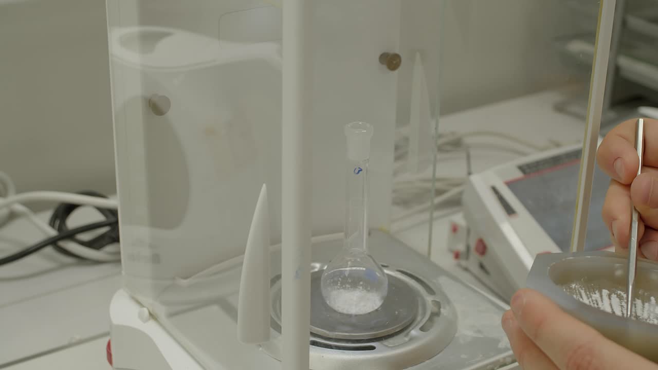 измерение веса лекарства, весы с лабораторной посудой или колбой для пробирок, крупный план