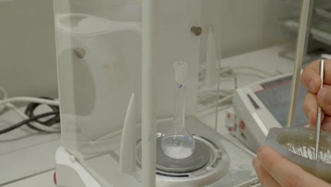 medición del peso del fármaco, escala con cristalería de laboratorio o matraz de tubo de ensayo, vista de cierre