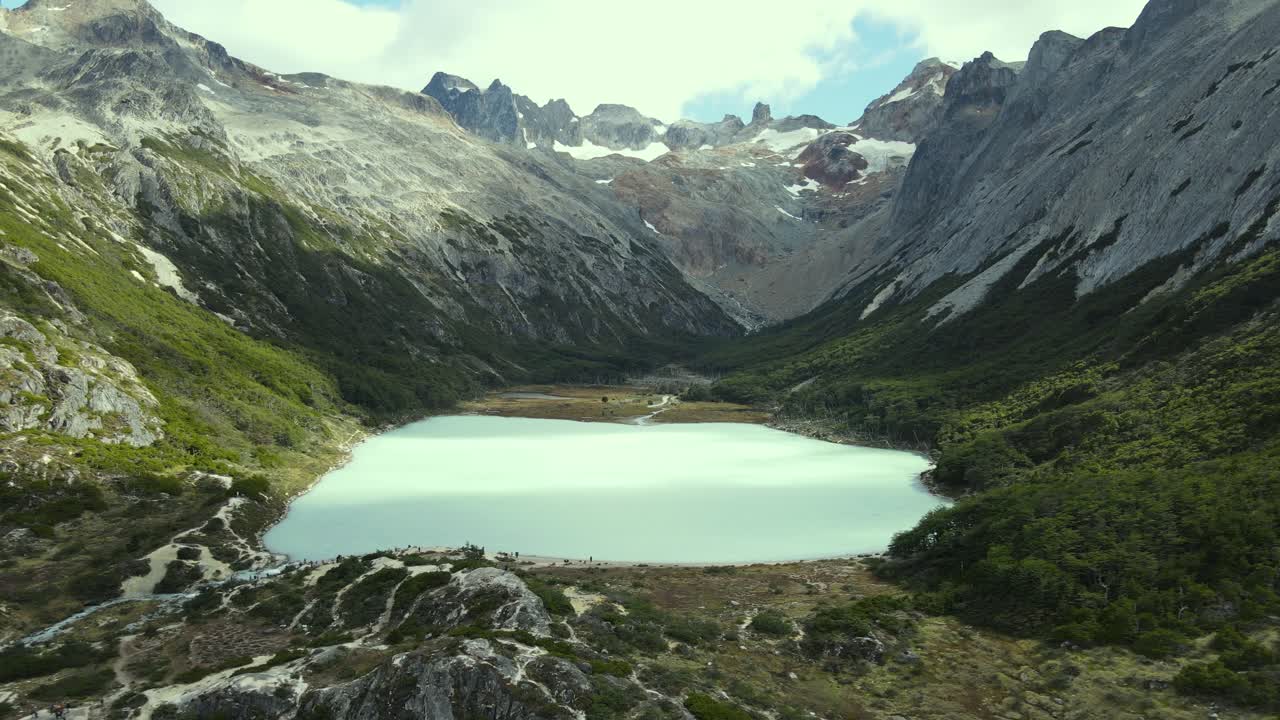 Aerial view of an emerald lagoon between mountains