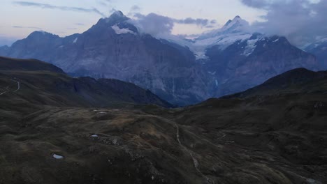 aerial flyover over lake bachalpsee in grindelwald, switzerland at twilight with a view of schreckhorn and wetterhorn