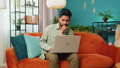 Amazed-Indian-man-use-laptop-computer,-receive-good-news-message,-shocked-by-victory,-celebrate-win