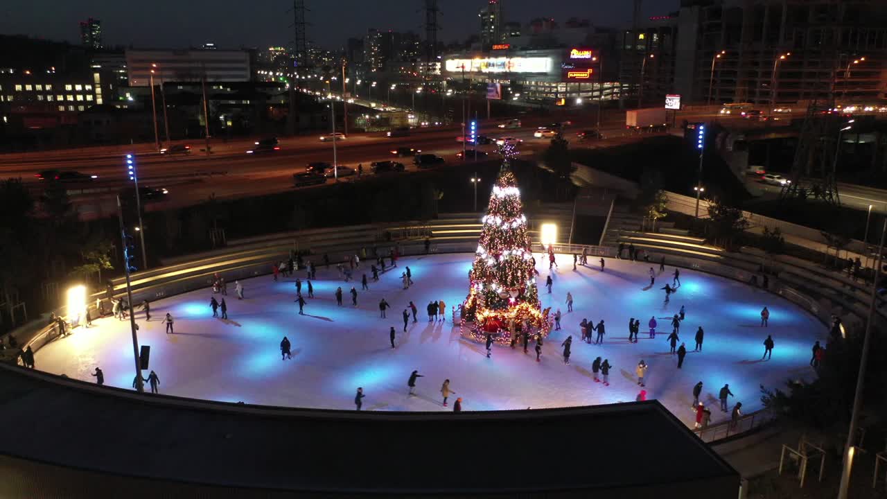 на коньках с рождественской елкой ночью