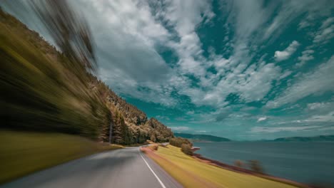 Eine-Rasante-Fahrt-Auf-Der-Schmalen-Zweispurigen-Landstraße-Entlang-Des-Ruhigen-Fjords-Bei-Sunndalsora,-Norwegen