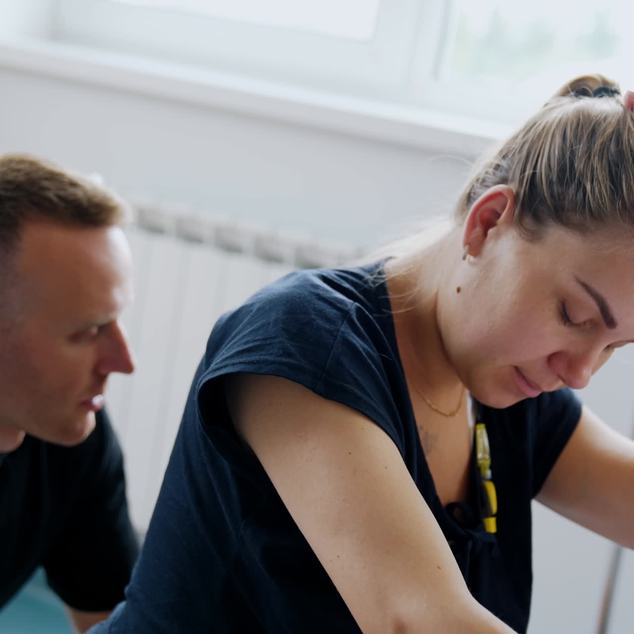 Woman before the delivery feeling pain from contractions. Husband sitting behind trying to sooth his wife rubbing her back