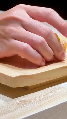 el chef coloca sushi en una tabla de madera.