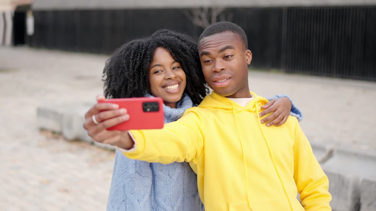 African young couple taking a selfie in the street