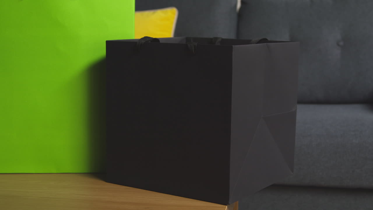 집 의 라운지 에 있는 테이블 에 태그 를 붙인 가방 에 선물 을 포장 한 선물 을 놓고 있는 남자 의 근접 사진