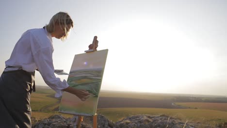 beautiful field at sunset. young girl artist who paints a picture of nature. - beautiful field at sunset