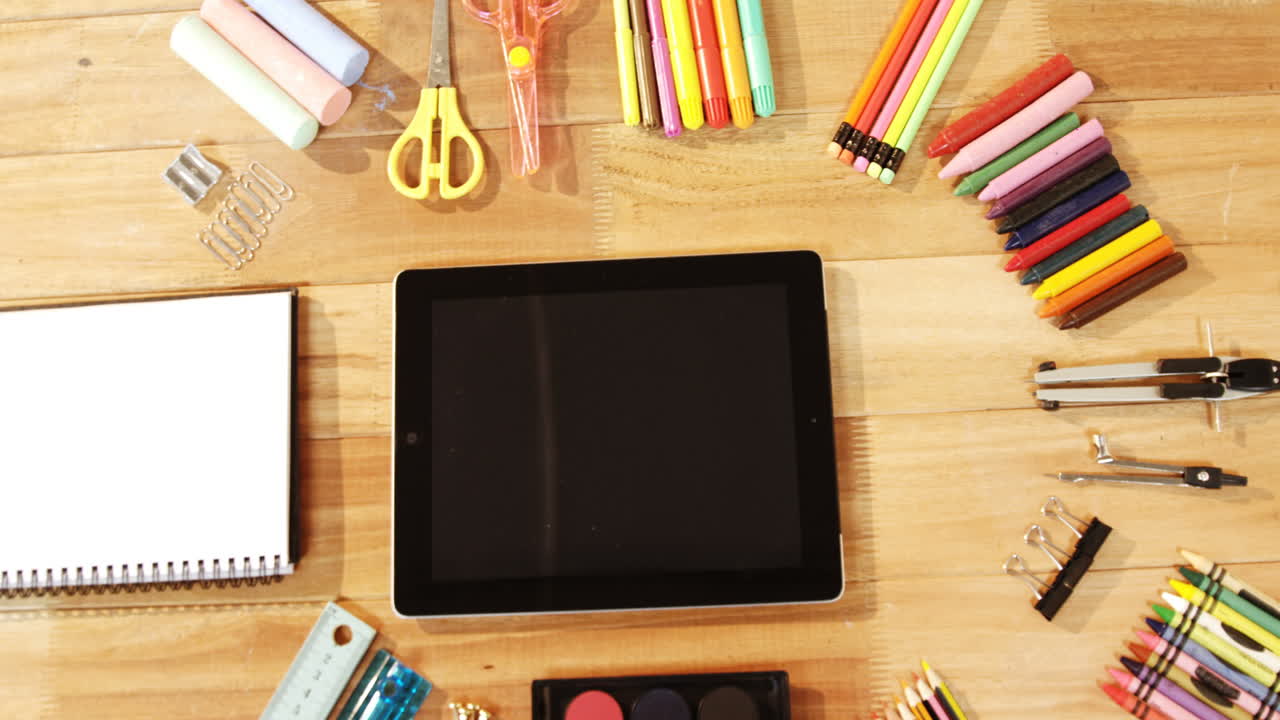 Close-up of digital tablet with various stationery