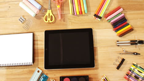 close-up of digital tablet with various stationery