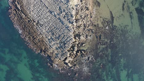 aerial top down view of rocky bay and crystal blue waters along lisbon's sunny coastline