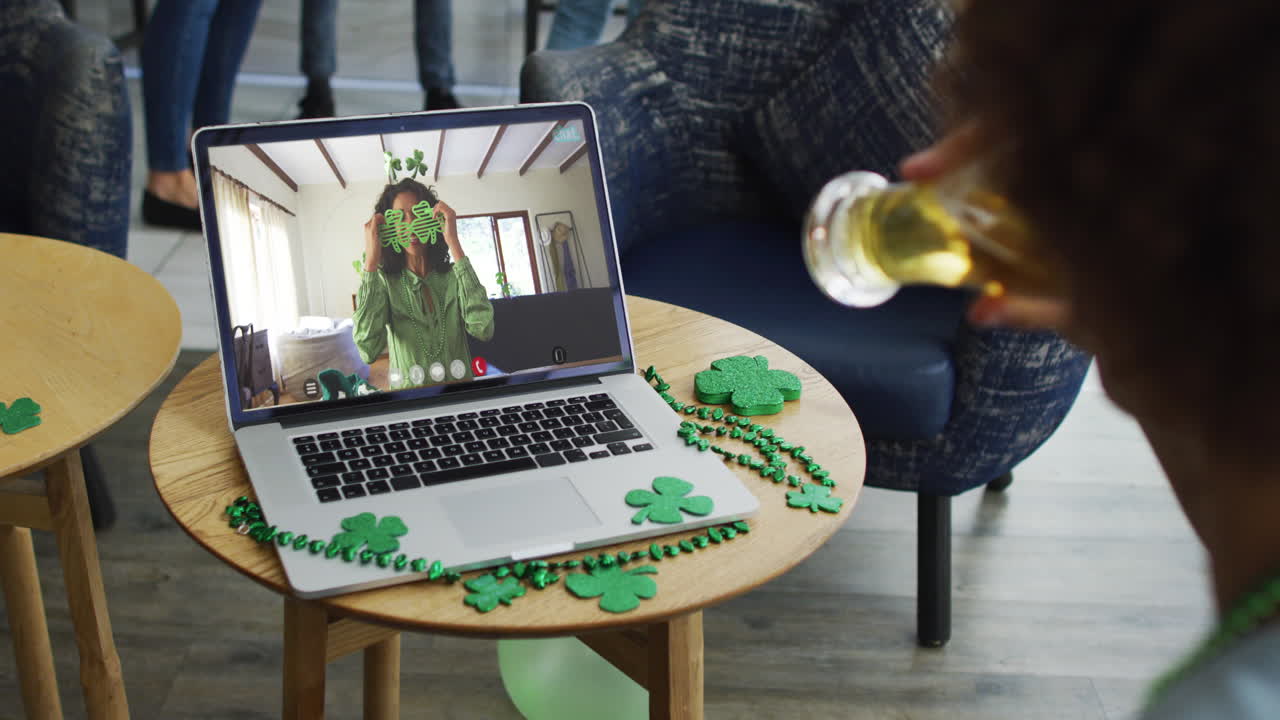 Man having beer on laptop video call celebrating st patrick's day with friends