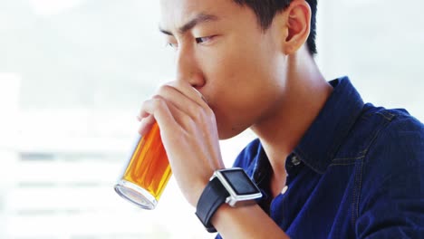 man sipping drink wearing smartwatch