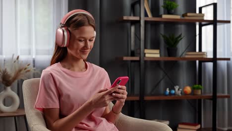 young woman enjoying music or content on her smartphone with headphones at home