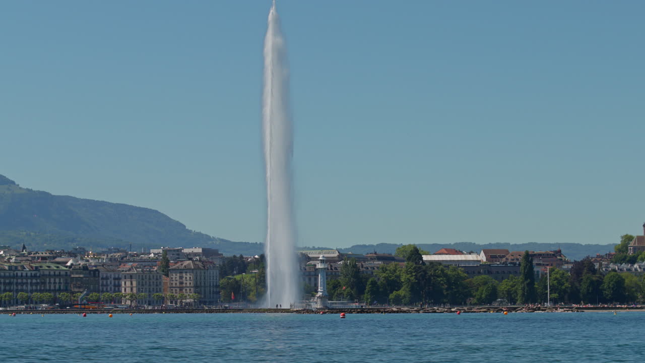 Peaceful morning in Geneva with the iconic Jet d’Eau rising from the lake, calm waters reflecting the clear sky, and the city slowly coming to life in the morning light.