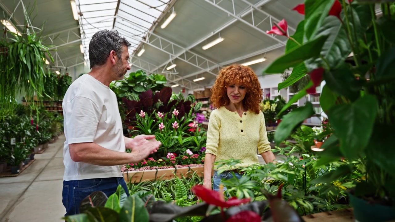 Casal Feliz Comprando Plantas em um Centro de Jardinagem Iluminado