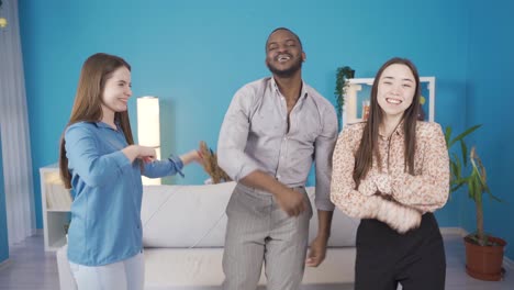 multiethnic group of young friends dancing at home.