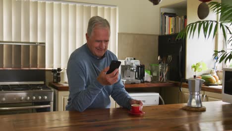 Senior-man-using-mobile-phone-at-home