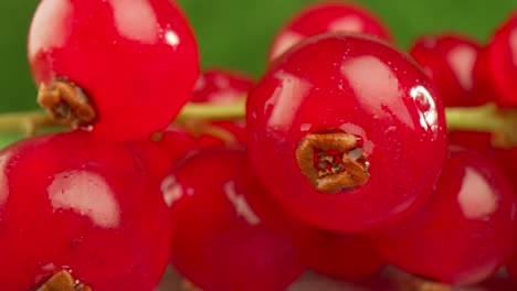 una macro muy cercana de una grosella roja en una mesa de madera.