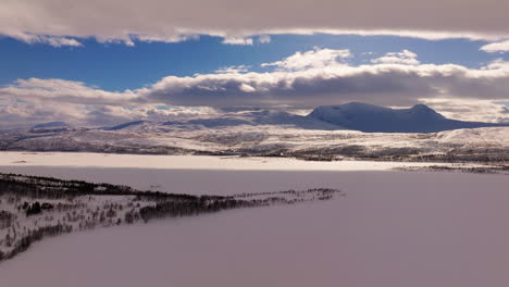 Frozen-lake-Takvatnet-covered-by-fresh-snow,-beautiful-winter-landscape,-Norway-rural-drone