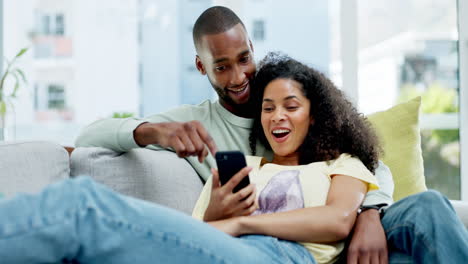 Couple,-phone-and-laughing-on-sofa-in-home