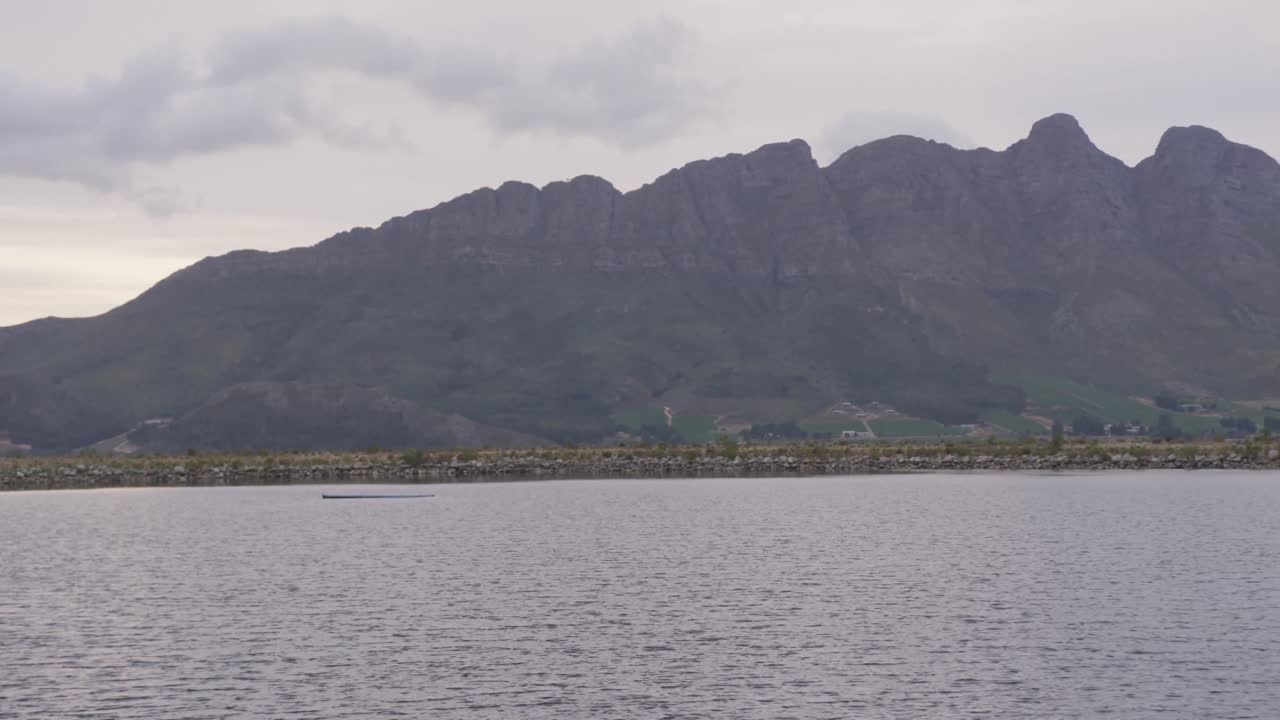구름이 많은 날 해가 지는 동안 호수와 산의 전망