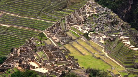 top view of the ancient inca city ruins of machu picchu nestled on a mountain ridge in peru - aerial shot