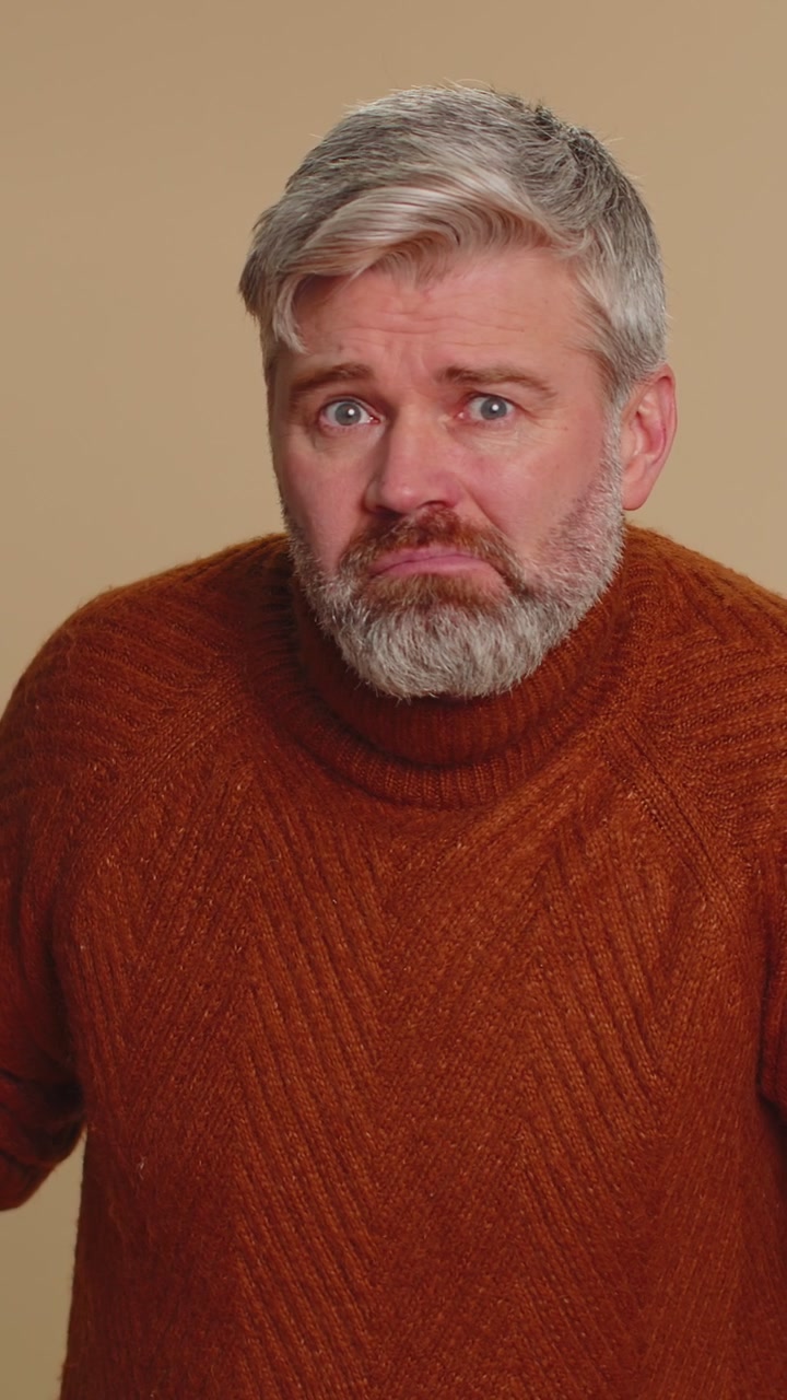 Middleaged man trying hear you looking confused and frowning keeping arm near ear for louder voice