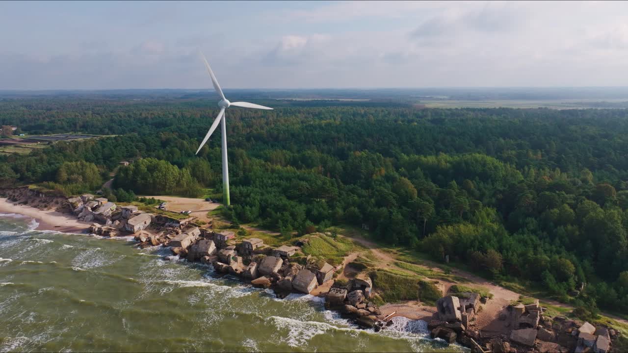 Langsomt fremadgående droneoptagelse, der afslører ruinerne af Nordfortet og en kystnær vindmølle.