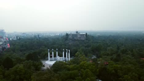 incline hacia abajo la órbita aérea con el castillo de chapultepec y el &quot;altar a la patria&quot; en un día nublado y misterioso sobre el bosque de chapultepec, el parque más hermoso del mundo, ciudad de méxico