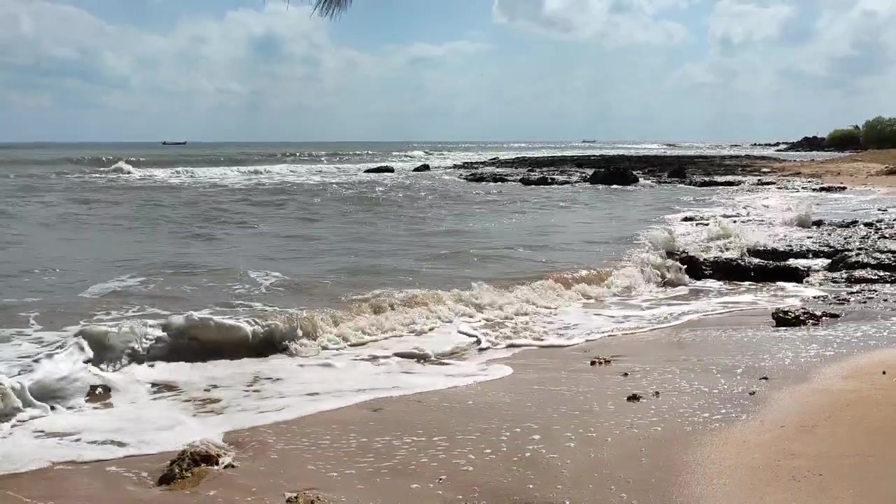Ondas Suaves Chegando a uma Praia Tropical Rochosa.