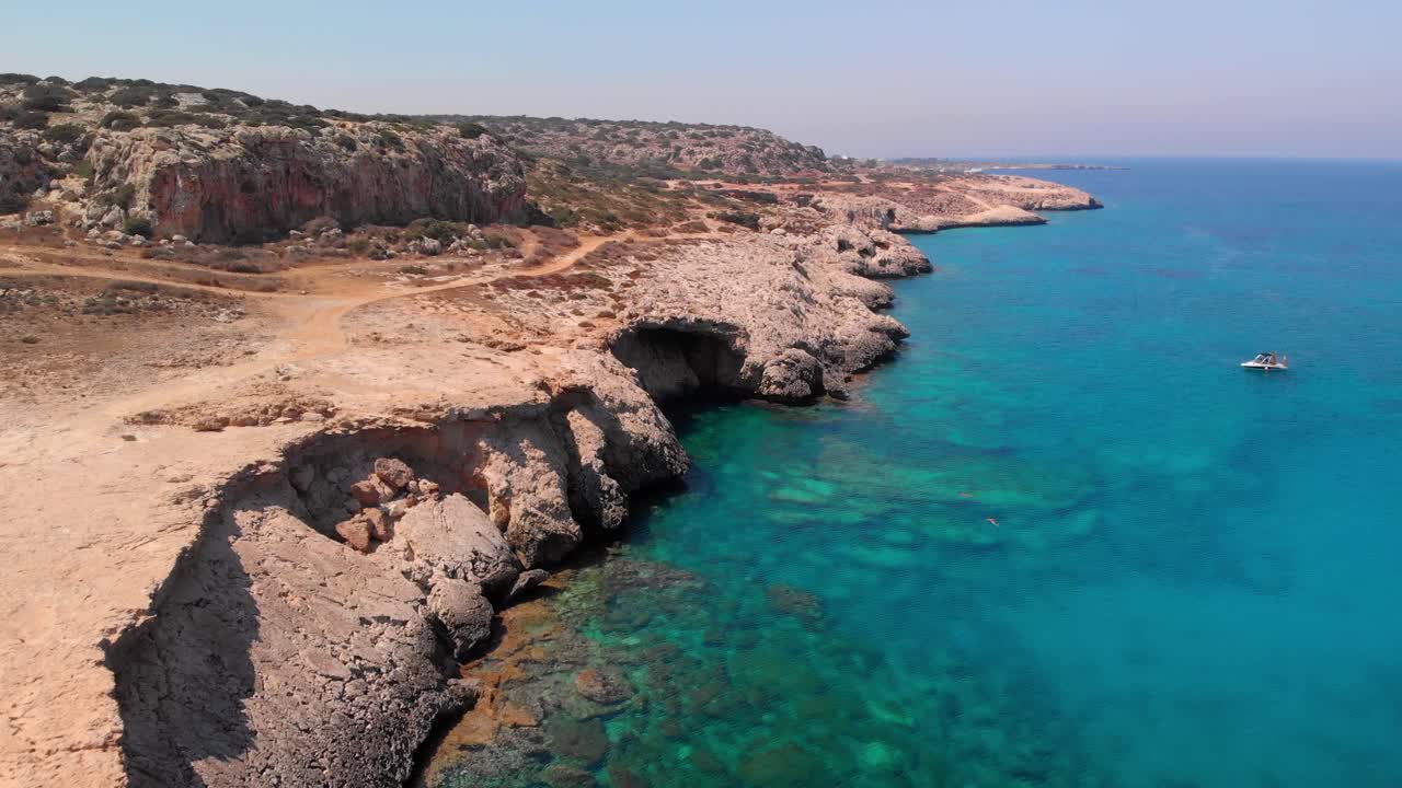fotografía en bajo ángulo de los acantilados de cabo greco frente al azul brillante del mar mediterráneo en chipre