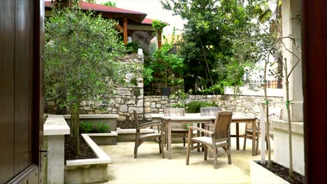 a quiet garden in old walls with a stylish table and chairs waiting for guests.