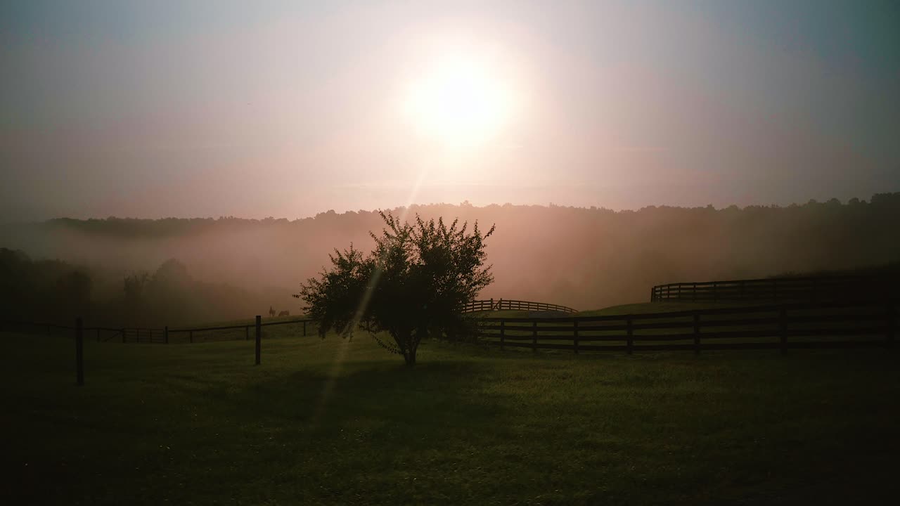 Sunrise over the misty farm fields