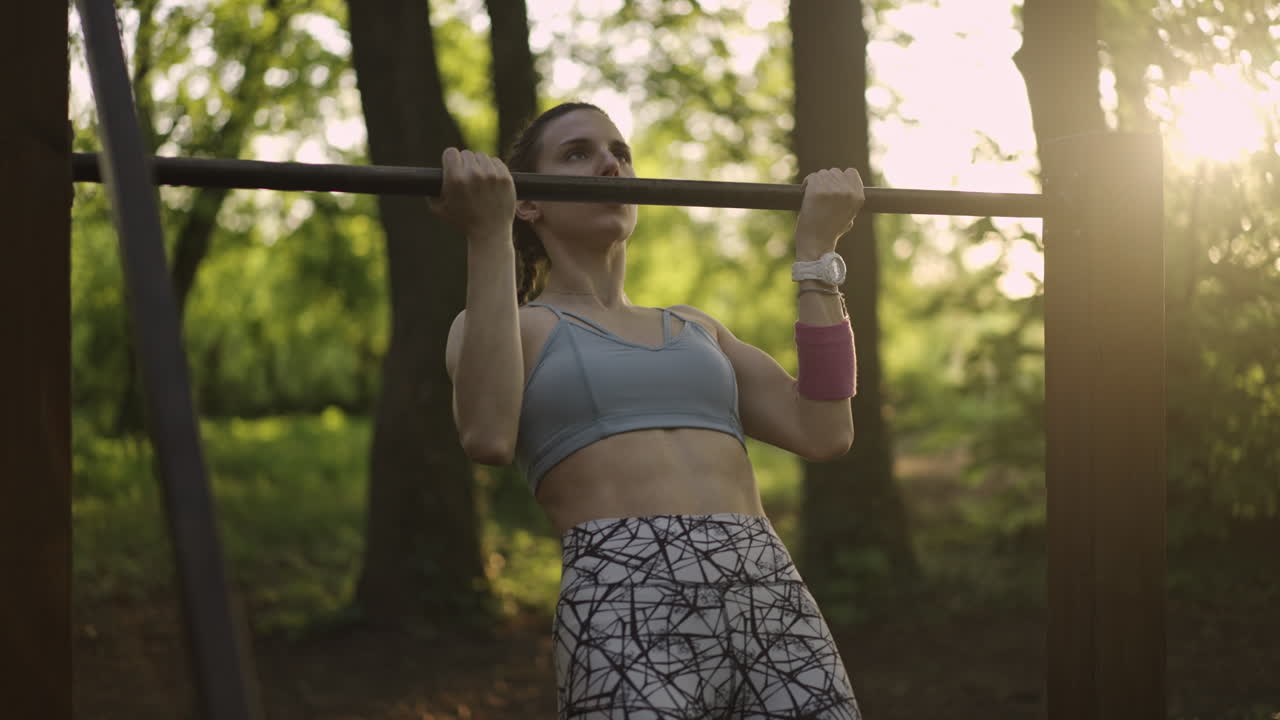 Woman doing pull ups in nature