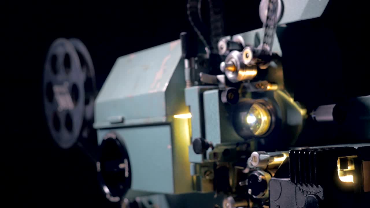 Old movie projector working in dark cinema hall. 4K.