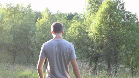 a man walks on a footpath in forest, daytime, summer season