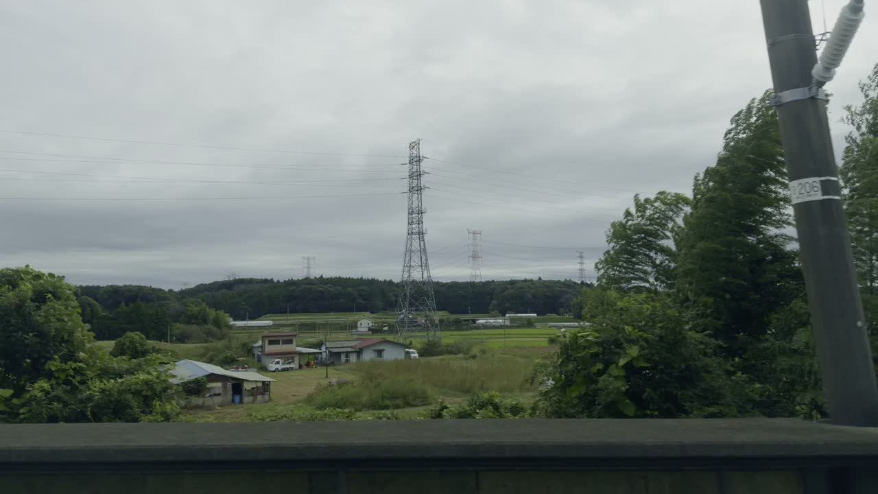 Japanese Countryside Scenery: Houses, Fields, and Power Lines Under an Overcast Sky