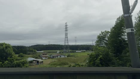japanese countryside scenery: houses, fields, and power lines under an overcast sky