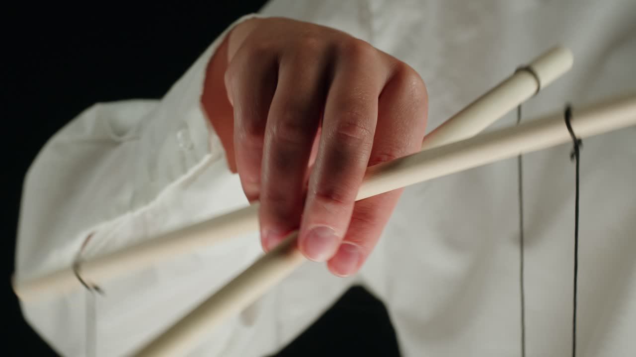 Close-up of Hand Manipulating Puppet Control Bars