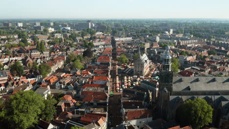 Vista-Aérea-De-La-Iglesia-De-Sint-jan,-El-Ayuntamiento-Histórico-Y-Los-Puestos-De-Mercado-Dentro-De-La-Ciudad-De-Gouda,-Países-Bajos