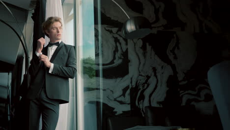 hombre en tuxedo junto a la ventana.