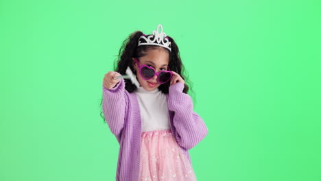 girl dressed as a princess with a tiara and heart-shaped sunglasses