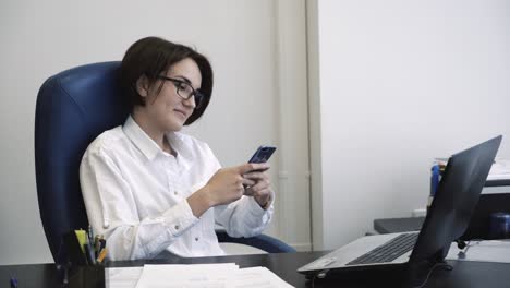 mujer trabajando en la oficina en la computadora portátil y el teléfono