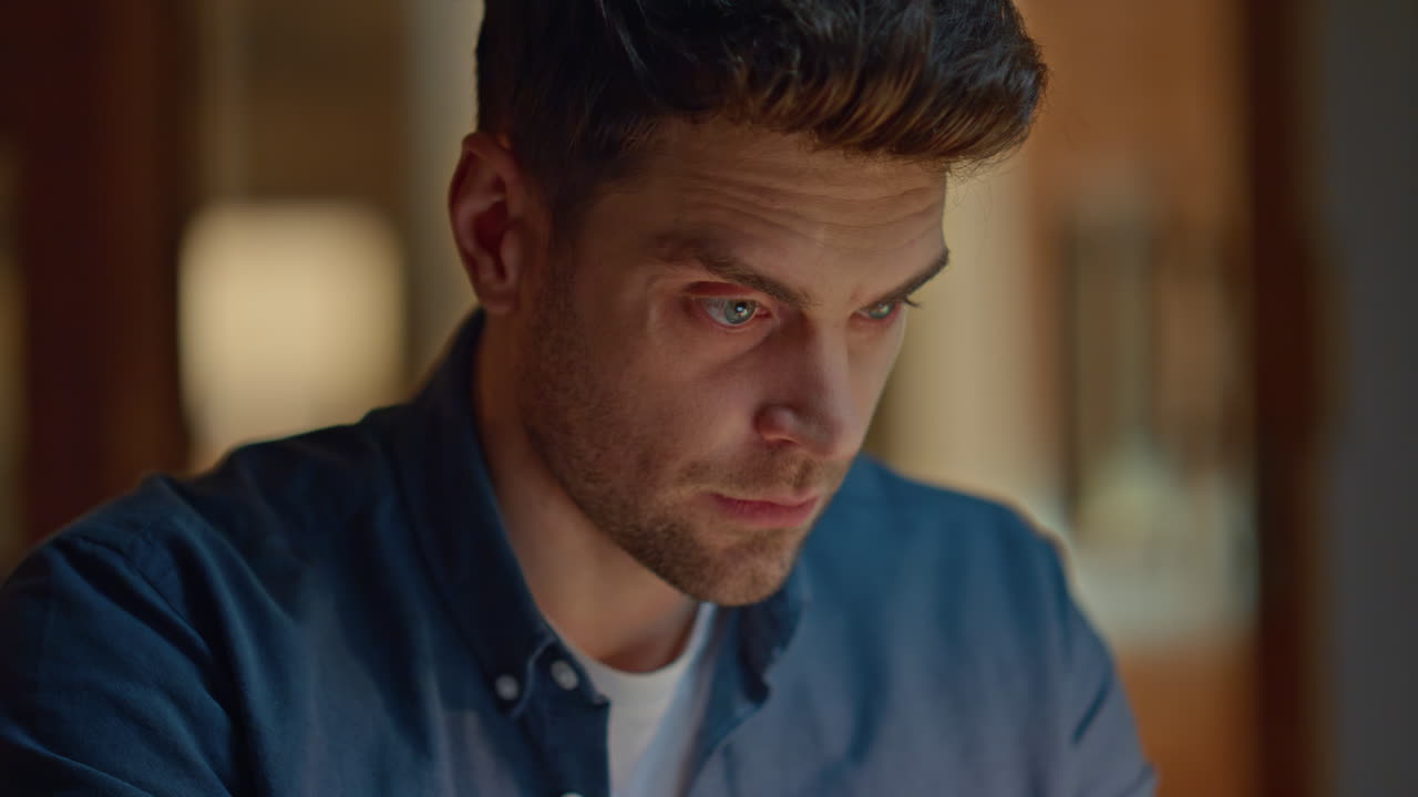 Tired freelancer working late at home closeup. Frowning man reading at evening