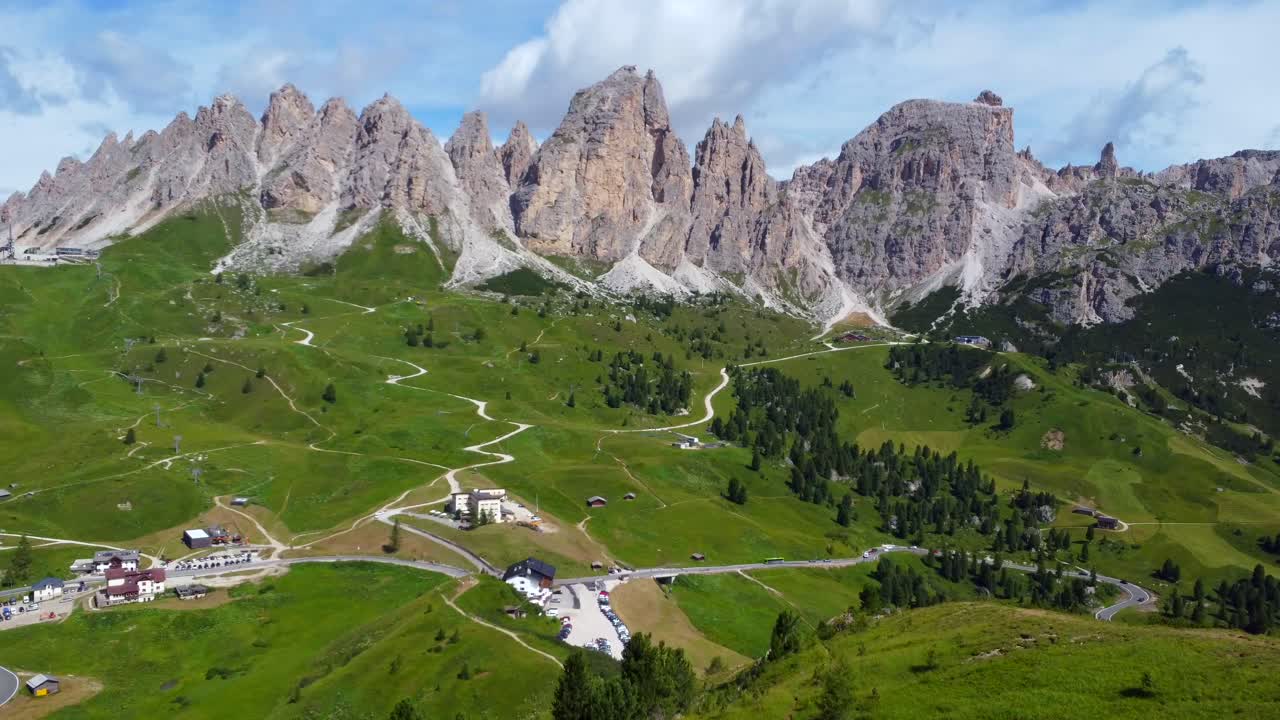 Snoede veje, der snor sig gennem frodige, grønne enge i Dolomitterne ved Gardena Pass