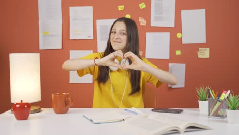 Niña-Haciendo-Símbolo-De-Corazón-Para-Cámara.